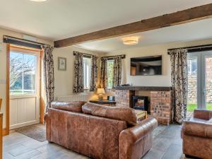 a living room with a couch and a fireplace at Milking Parlour - Uk48911 in Allonby