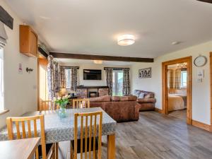 a living room with a table and a couch at Milking Parlour - Uk48911 in Allonby +13 photos