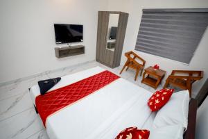a bedroom with a white bed and a television at Royal La Casa in Cochin +8 photos