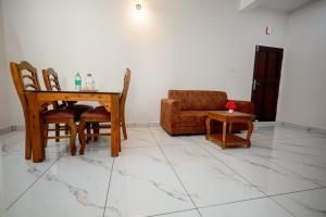 a living room with a table and chairs at Royal La Casa in Cochin