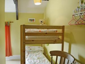 a bunk bed with a teddy bear sitting on top at Sandsedge Cottage in Ellington +4 photos