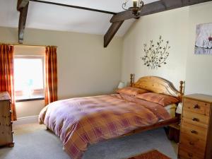 a bedroom with a bed and a dresser and a window at Sandsedge Cottage in Ellington