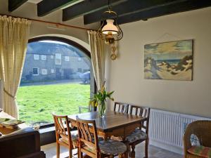 a dining room with a table and chairs and a window at Sandsedge Cottage in Ellington