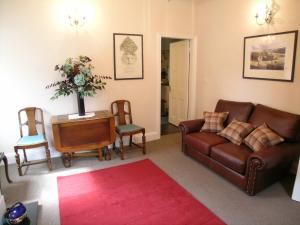 a living room with a leather couch and chairs at Ted's House in Mytholmroyd
