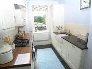 a kitchen with a stove and a sink and a window at Ted's House in Mytholmroyd