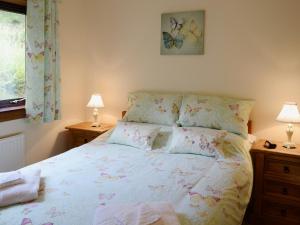a bedroom with a bed and two lamps and a window at Deo Na Mara in Midtown Brae
