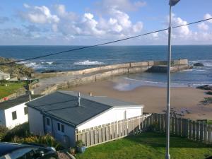 a view of a beach with a building and the ocean at Bayview in Collieston