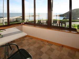a room with windows with a view of the ocean at Bayview in Collieston +6 photos
