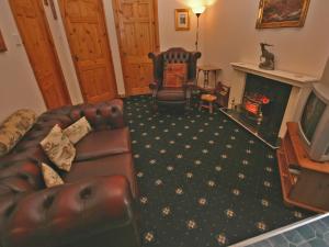 a living room with a couch and a fireplace at Lochview Barn in Strathyre