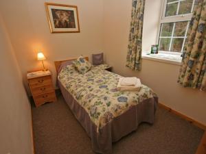 a small bedroom with a bed and a window at Lochview Barn in Strathyre