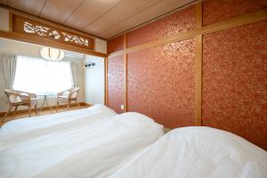 a bedroom with two beds and a table and a window at Villa Shigin in Nakafurano +68 photos
