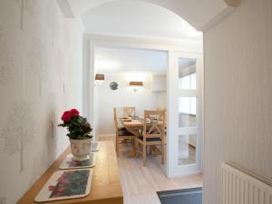 a kitchen and dining room with a table and a vase of flowers at Strone Farm House in Torcastle