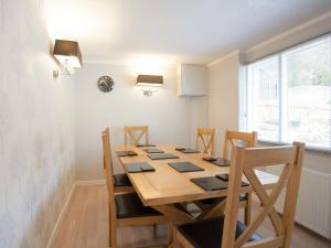 a dining room with a wooden table and chairs at Strone Farm House in Torcastle