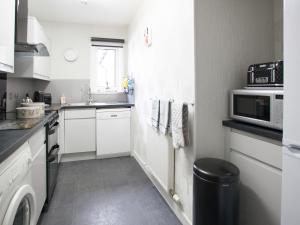 a small kitchen with a sink and a microwave at Strone Farm House in Torcastle +11 photos