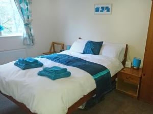 two towels on a bed in a bedroom at Belle Isle Cottage in Haworth