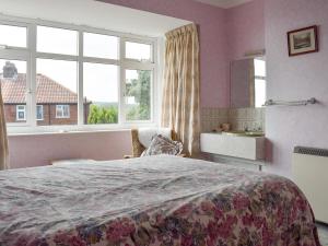 a bedroom with a large bed and a window at Rose Garth in Robin Hood's Bay