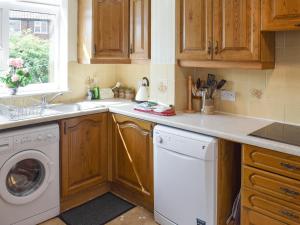 a kitchen with a washing machine and a sink at Rose Garth in Robin Hood's Bay