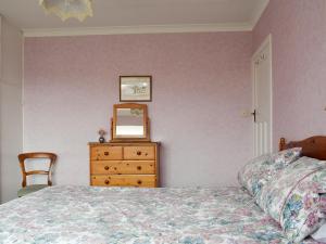 a bedroom with a bed and a dresser and a mirror at Rose Garth in Robin Hood's Bay +6 photos