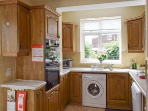 a kitchen with a washing machine and a window at Rose Garth in Robin Hood's Bay