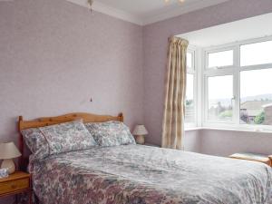a bedroom with a bed and a large window at Rose Garth in Robin Hood's Bay