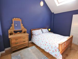 a bedroom with a bed and a dresser and a mirror at Dornock Brow Cottage in Dornock