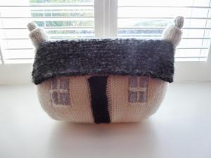 a crocheted house doll sitting in front of a window at Crosskeys Cottage in Shandon +13 photos