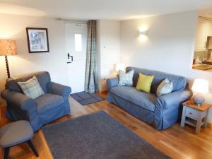 a living room with a couch and a chair at Crosskeys Cottage in Shandon