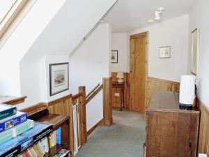 a room with a staircase with a book shelf at Sanctuary Cottage in Applecross