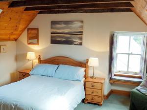 a bedroom with a bed and a window at Sanctuary Cottage in Applecross