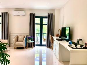 a living room with a television and a desk with a chair at Khách sạn LAVENDER - Vincom Tây Ninh in Tây Ninh
