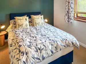 a bedroom with a bed with a blue and white comforter at Kildonan in Laide