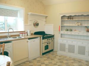a kitchen with a sink and a stove at Palmallet Cottage in Whithorn