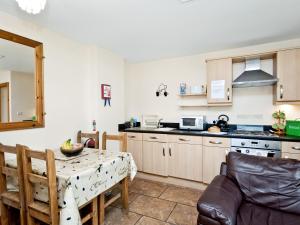 a kitchen with a table and a dining room at Cobble Cottage - W41945 in Filey