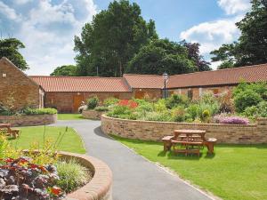 a garden with a picnic table and a brick building at Cobble Cottage - W41945 in Filey +2 photos