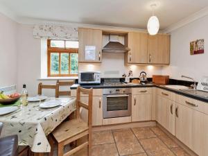 a kitchen with wooden cabinets and a table with a tableablish at Trueman - W41948 in Filey