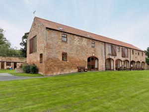 a large brick building with a large grass yard at Trueman - W41948 in Filey +7 photos