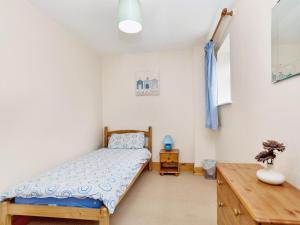 a bedroom with a bed and a wooden dresser at Trueman - W41948 in Filey