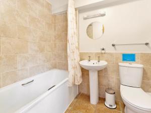 a bathroom with a sink and a toilet and a tub at Trueman - W41948 in Filey