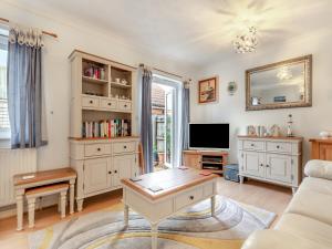 a living room with a couch and a tv at Chaucer Rise in Exmouth