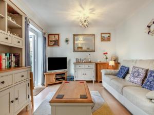 a living room with a couch and a tv at Chaucer Rise in Exmouth