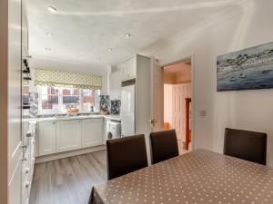 a kitchen and dining room with a table and chairs at Chaucer Rise in Exmouth +16 photos