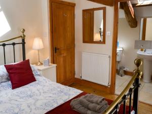 a bedroom with a bed and a mirror and a sink at Knoppingsholme Stable in Greenhaugh