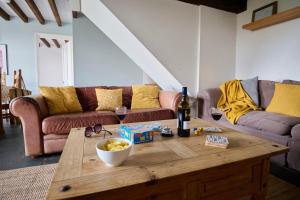 a living room with a table with wine glasses and a couch at Granary - Ukc4684 in Clynnog-fawr