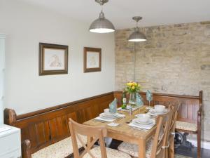 a dining room with a wooden table and chairs at The Smithy in Ovingham