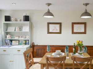 a dining room with a wooden table and chairs at The Smithy in Ovingham