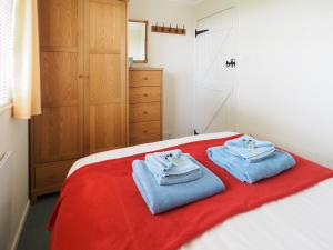 a bedroom with a bed with two towels on it at Ash Lodge in Nawton