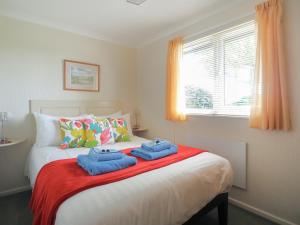 a bedroom with a bed with two towels on it at Ash Lodge in Nawton