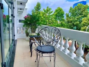 a balcony with two chairs and plants on it at Khách sạn LAVENDER - Vincom Tây Ninh in Tây Ninh