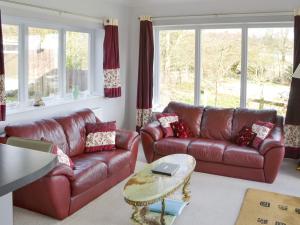 a living room with two leather couches and a table at Heatherlea in Otterburn