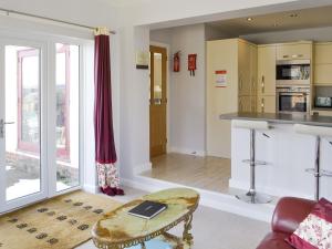 a living room with a table and a kitchen at Heatherlea in Otterburn